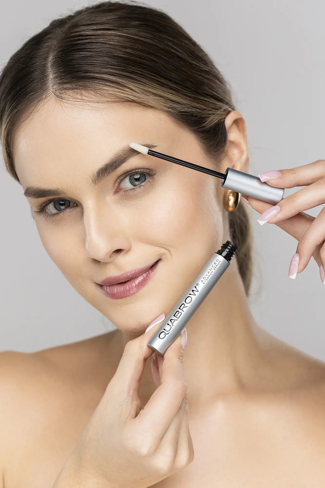 Kvinde, der påfører QUABROW Advanced Eyebrow Serum på lyse øjenbryn