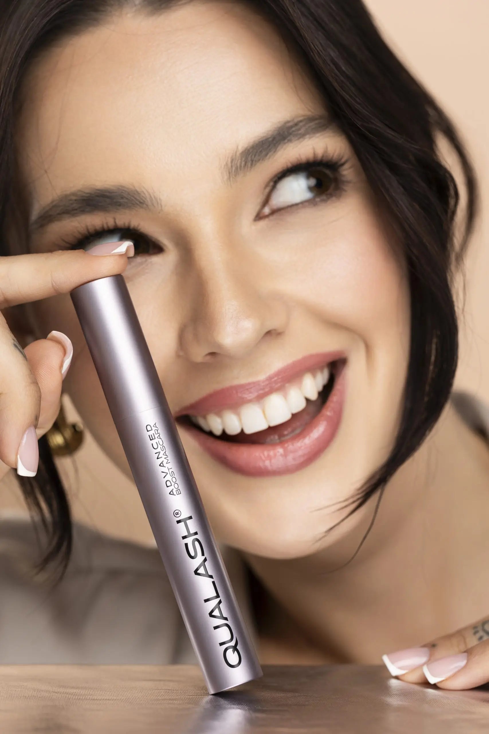 Kvinde påfører QUALASH Advanced Mascara Volume Max på de øverste vipper med præcisionsbørste – Trin 1